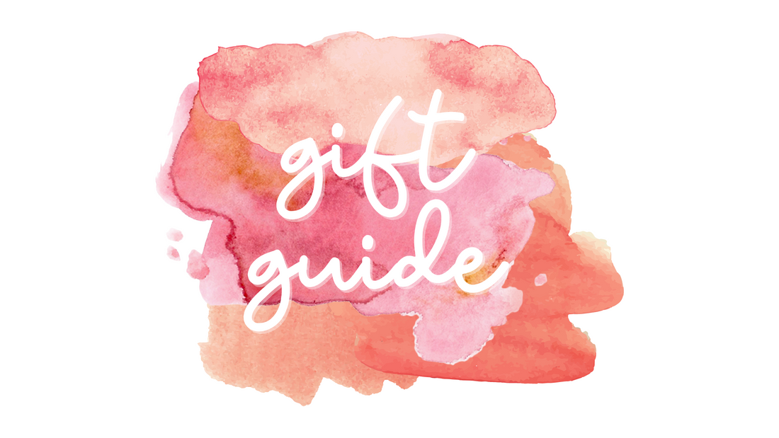 A pink and red watercolor background with the words "gift guide" written in cursive