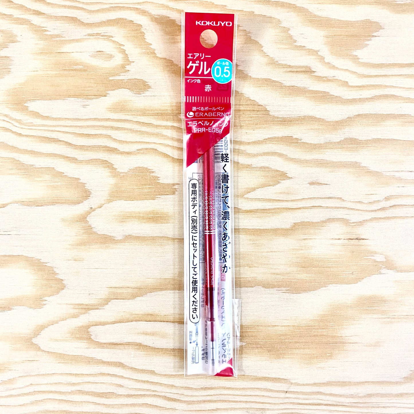 A refill cartridge with red ink in its original packaging.