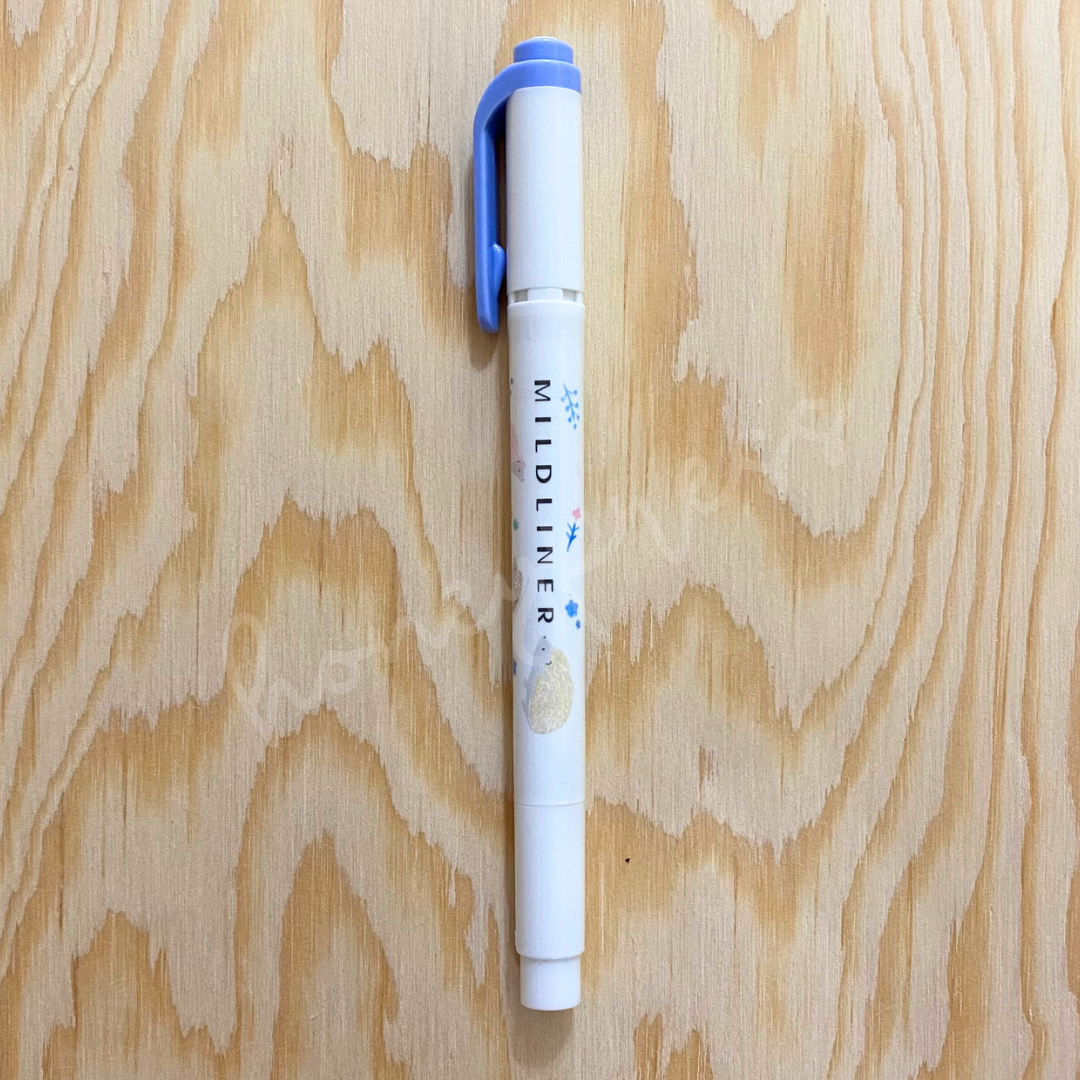 An upright highlighter with a blue colored cap, white body, and a hedgehog image.