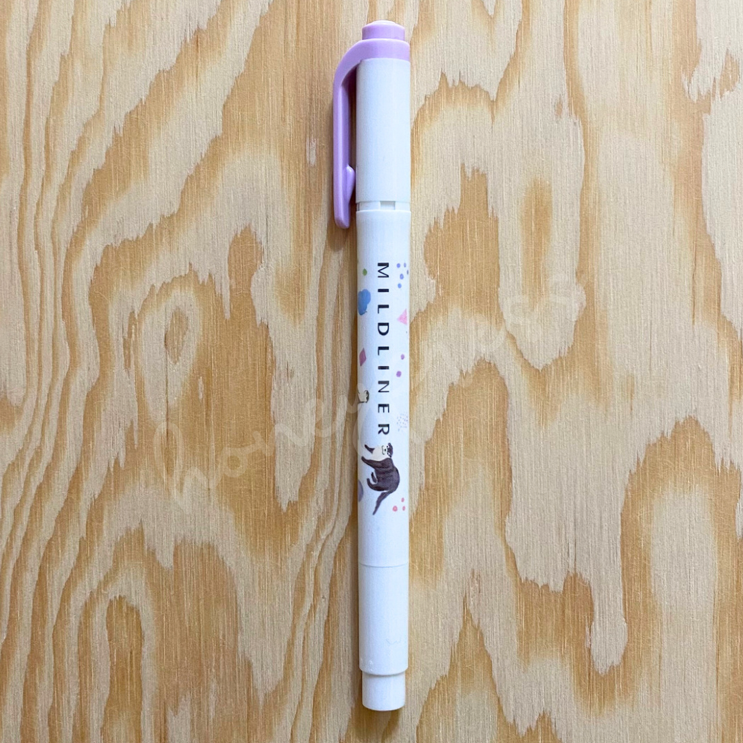 An upright highlighter with a lavender colored cap, white body, and an otter image.