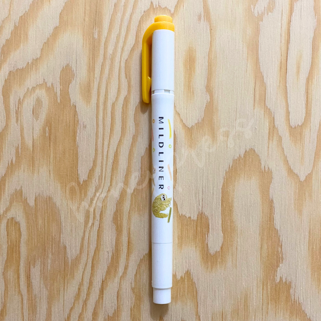 An upright highlighter with a golden yellow colored cap, white body, and a sloth image.