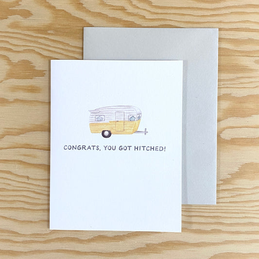 A greeting card with an illustration of a yellow and white colored trailer hitch.